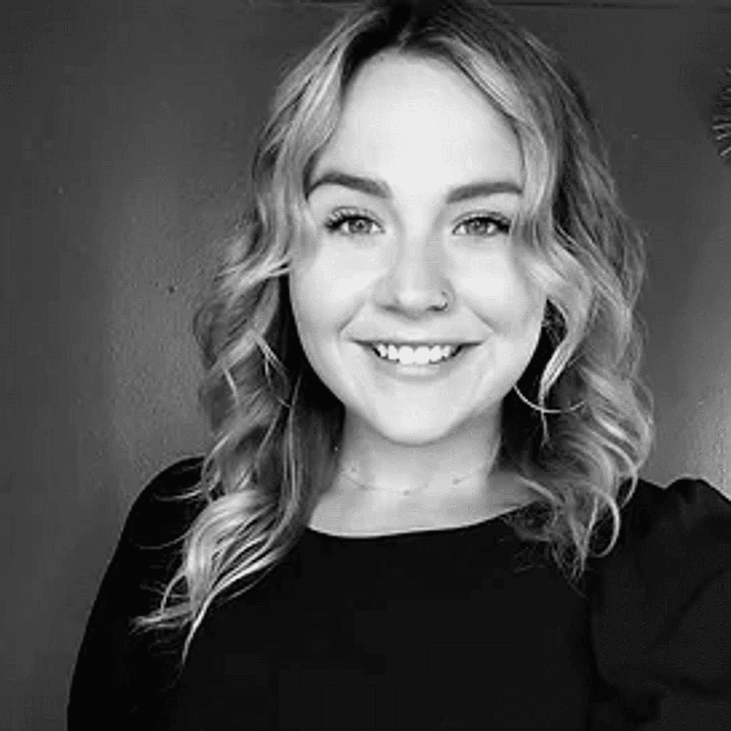 Portrait of Emily, a professional stylist at Good Vibes Salon, showcasing their expertise and style.